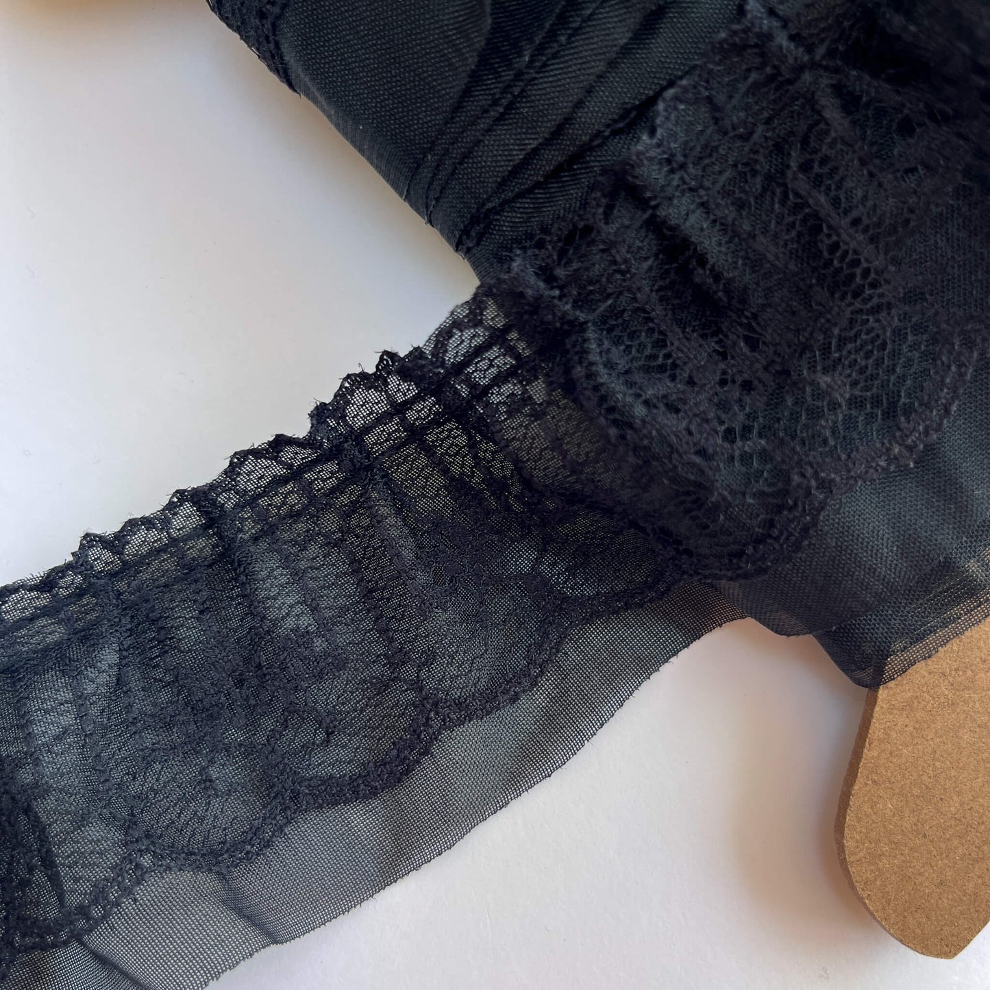 Close-up of black lace fabric on a white background