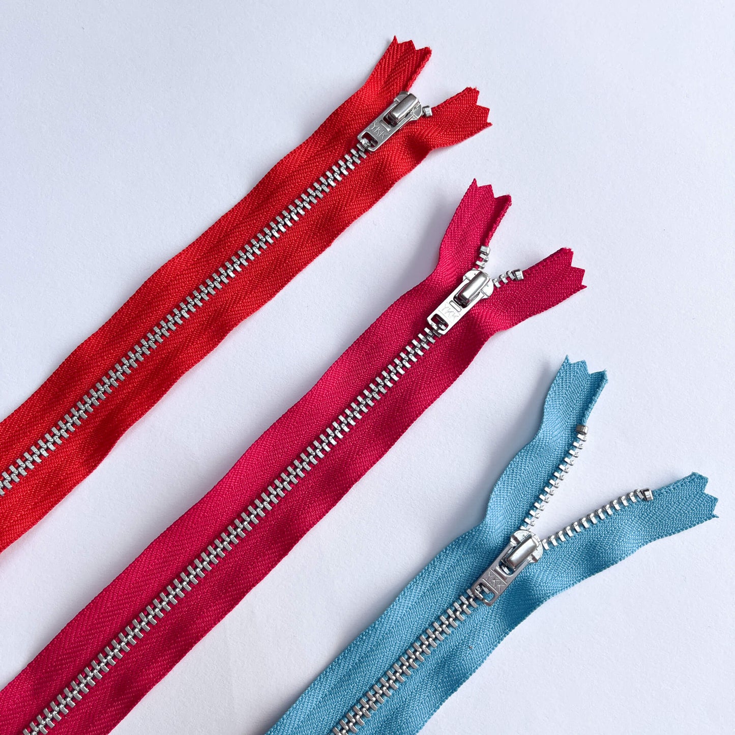 YKK #4.5 closed End SILVER Zip, 70cm length YKK jeans zip with SILVER metal teeth and auto-lock puller in orange, pink and blue shades - Kleins Haberdashery