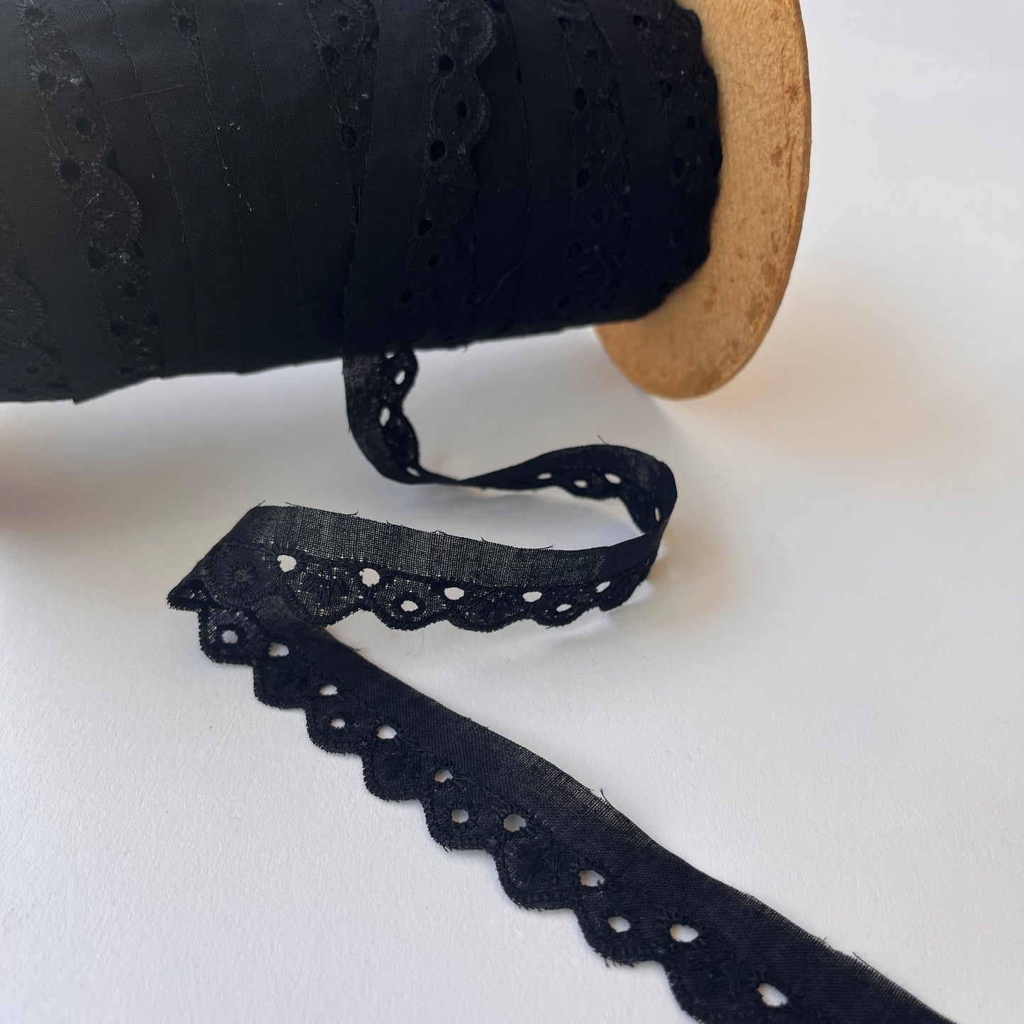 Narrow Broderie Anglaise cotton trim with scalloped edge in black. 2cm overall width / 1cm embroidered width , KLEINS HABERDASHERY. Choose our range of vintage lace, trims & sewing accoutrement rescued from a London haberdasher. Sew sustainably.