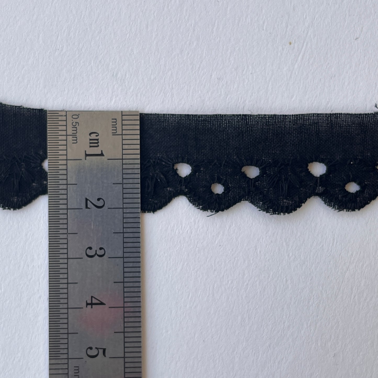 Narrow Broderie Anglaise cotton trim with scalloped edge in black. 2cm overall width / 1cm embroidered width , KLEINS HABERDASHERY. Choose our range of vintage lace, trims & sewing accoutrement rescued from a London haberdasher. Sew sustainably.