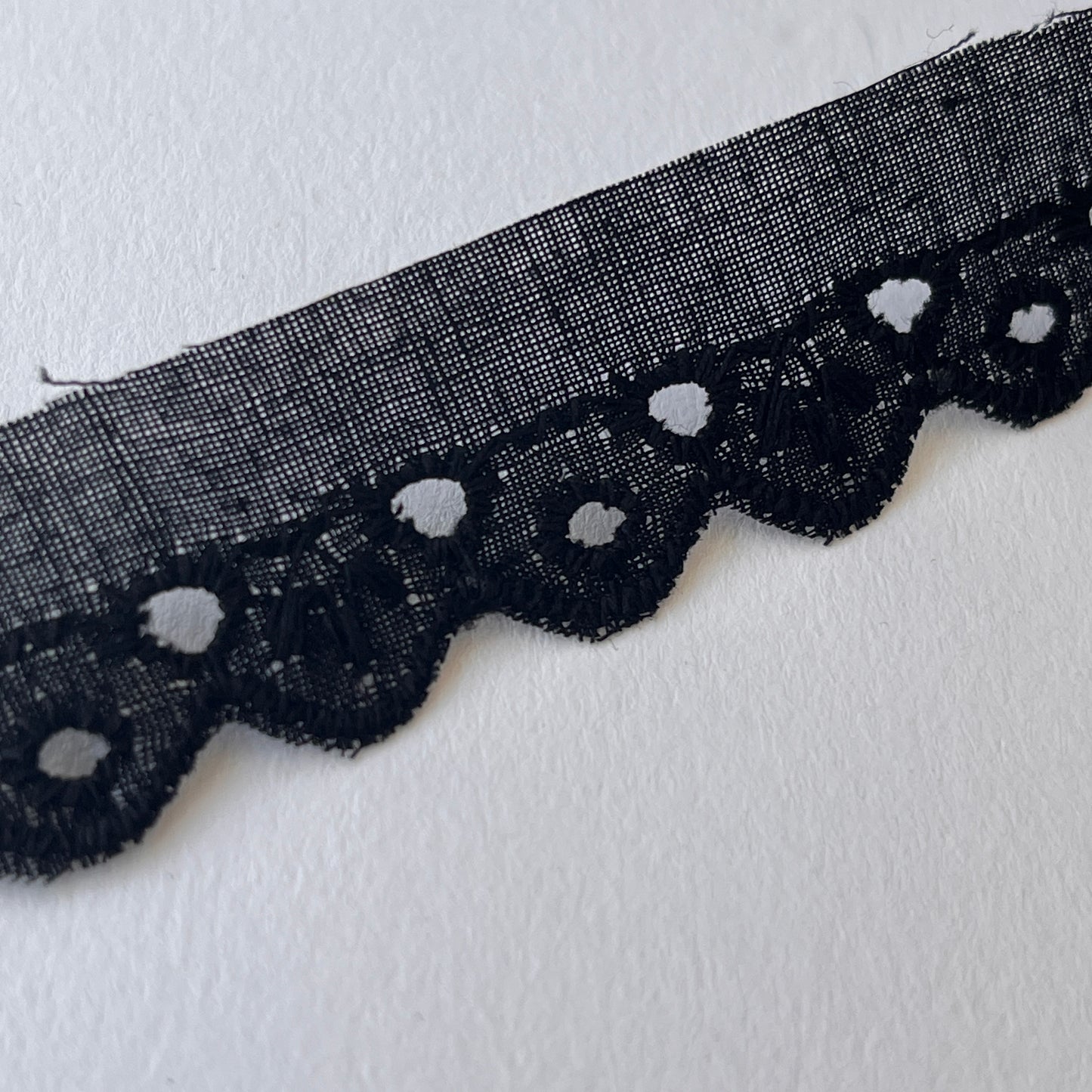 Narrow Broderie Anglaise cotton trim with scalloped edge in black. 2cm overall width / 1cm embroidered width , KLEINS HABERDASHERY. Choose our range of vintage lace, trims & sewing accoutrement rescued from a London haberdasher. Sew sustainably.