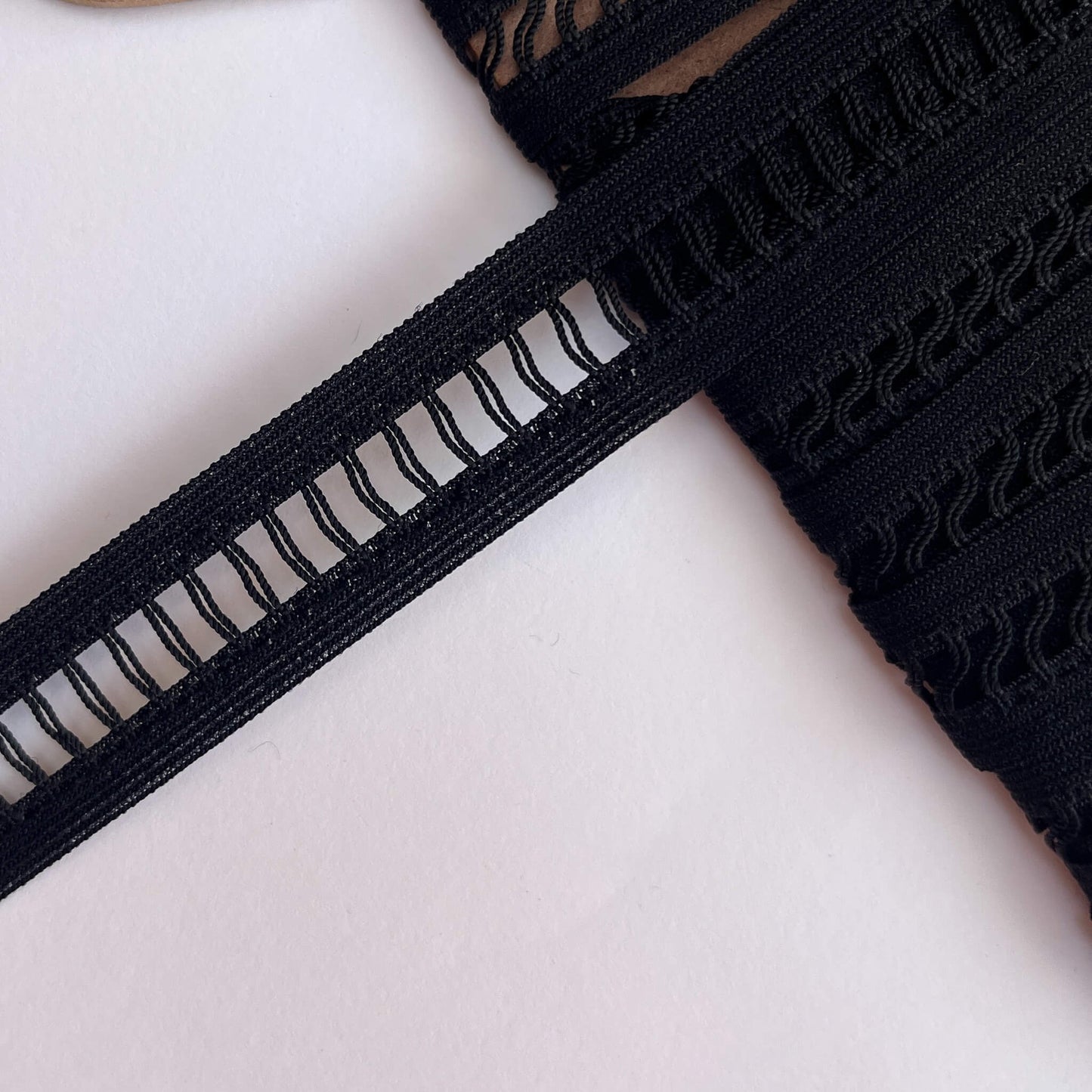 Close-up of Black Ladder Braid insertion Trim on a white background