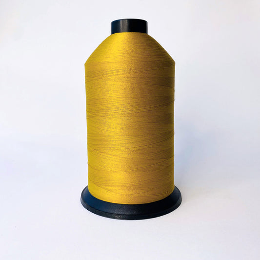 Spool of gold 740 thread on a white background