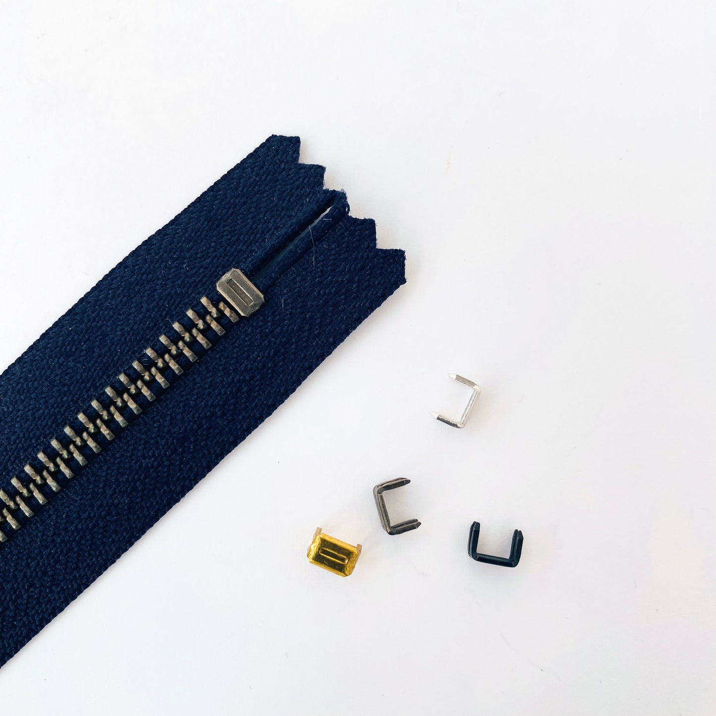 Bottom stop for metal zippers