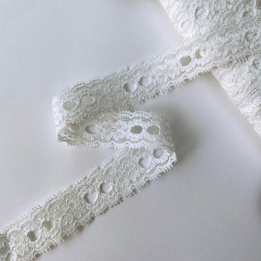Close-up of white scalloped Ribbon Slot Lace with eyelets