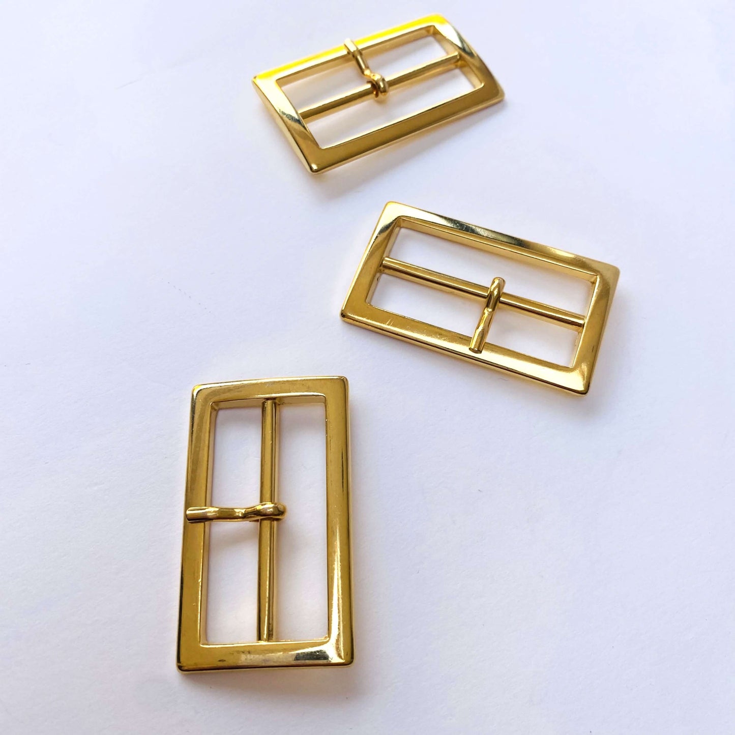 Gold Rectangle Prong Buckle - 40mm - Three gold belt buckles on a white background