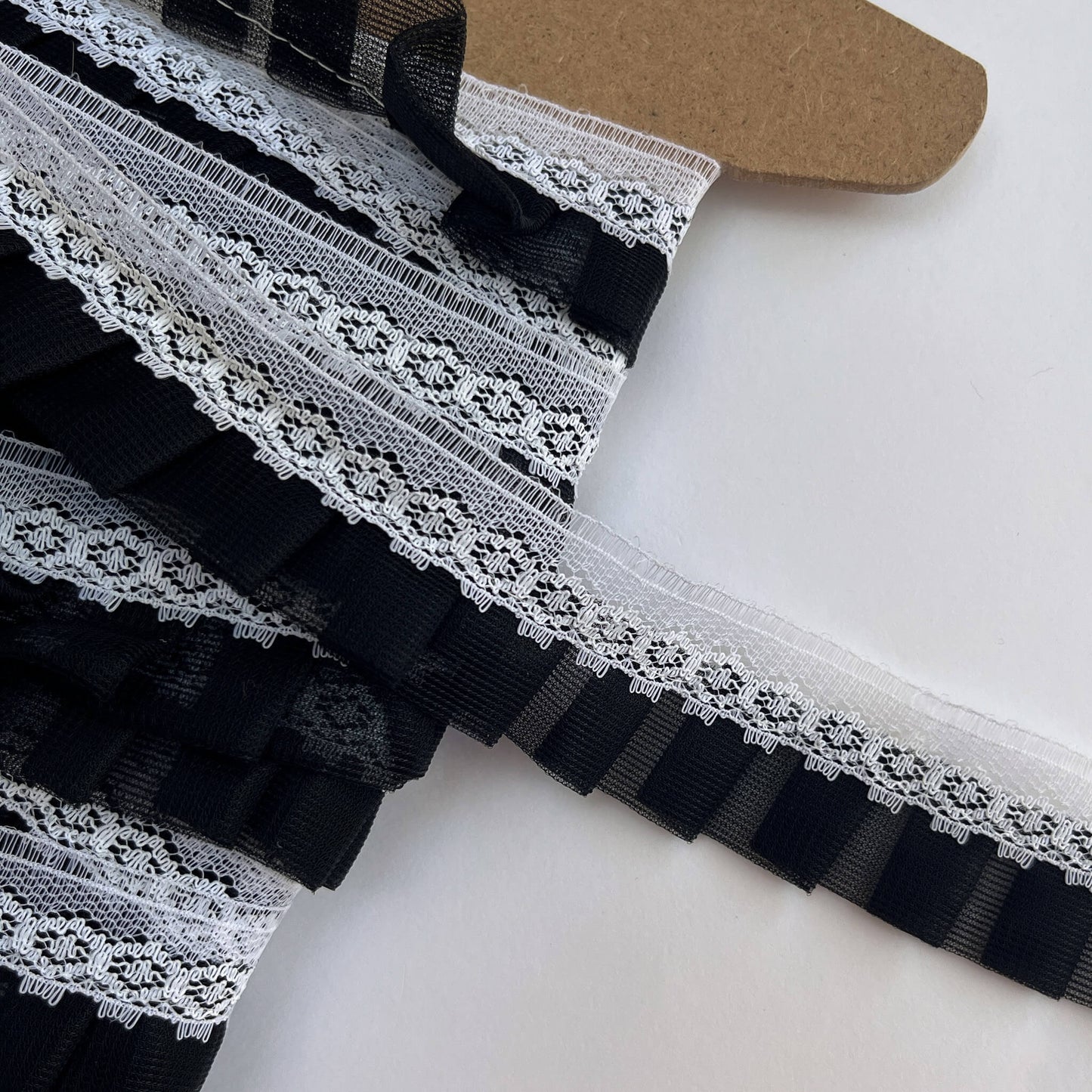 Black and white lace trim on a cardboard sample card.