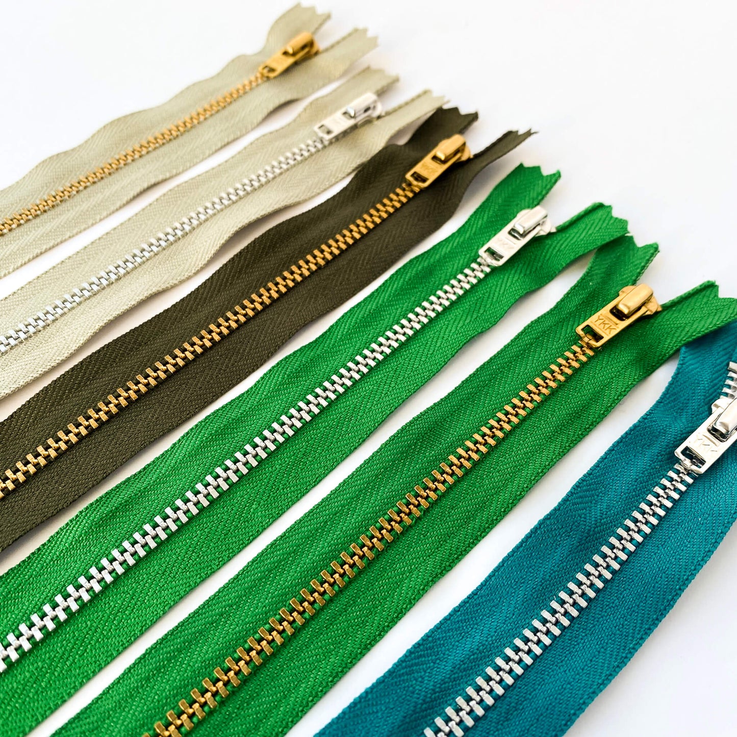YKK jeans zip with metal teeth and auto-lock puller in various shades of green
