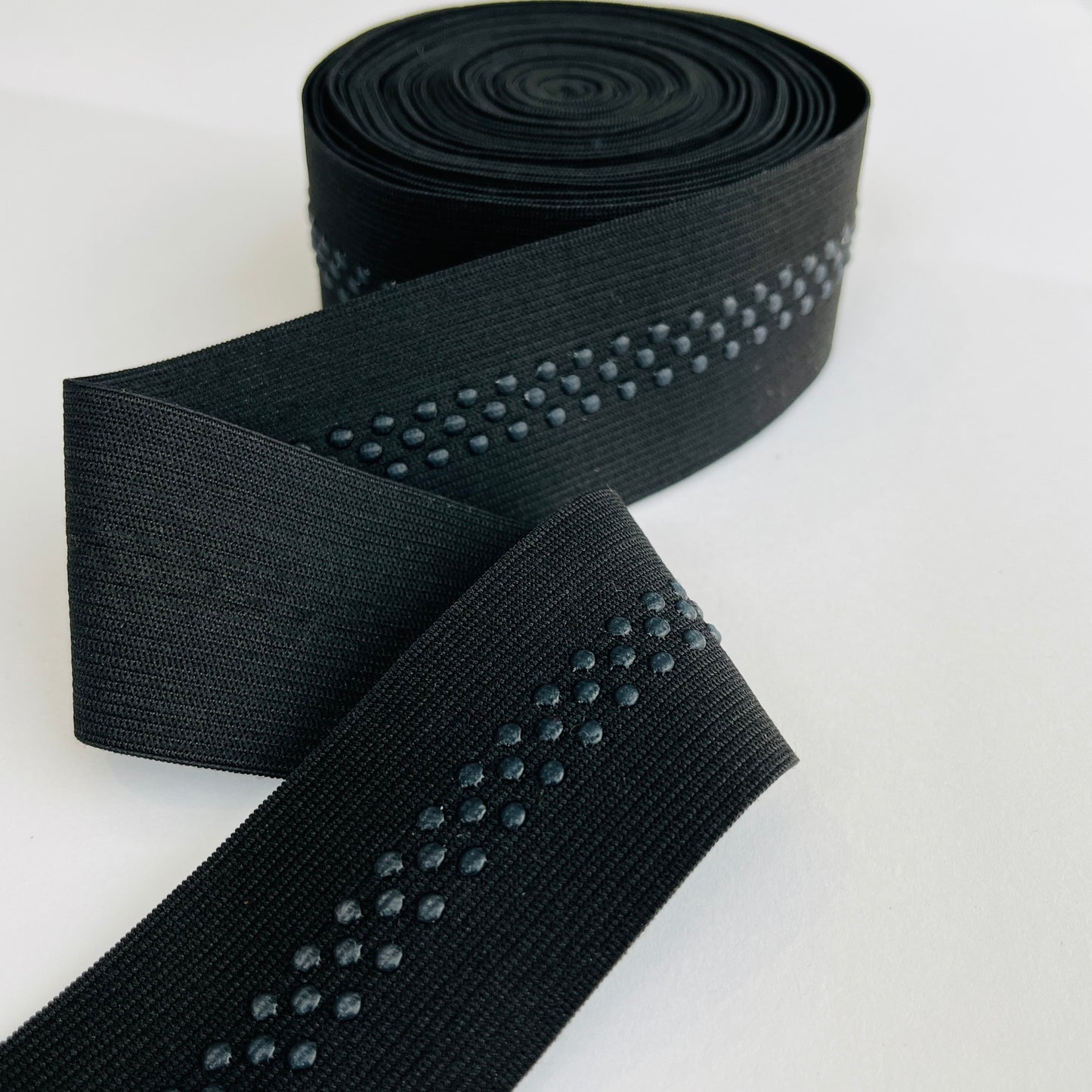 48mm, 2” wide silicone backed gripper elastic for headbands, waists, bra straps and lingerie 48mm wide with the drop silicone beads running at a 10mm width dead centre Soft gripper elastic with a 10mm wide band of non-slip silicone beads running centrally to help prevent movement when worn. Perfect for headbands, waistbands, activewear and lingerie.