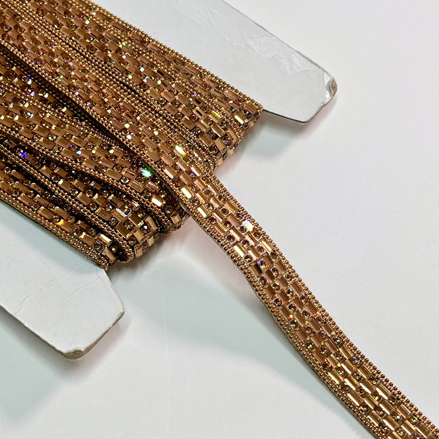 A stunning Art Deco inspired trim created with crystals and baguette shaped polished stones for sparkle, with a tiny twin bead edging. This is an iron-on embellishment with a transparent gel backing film and is very easy to cut to length.