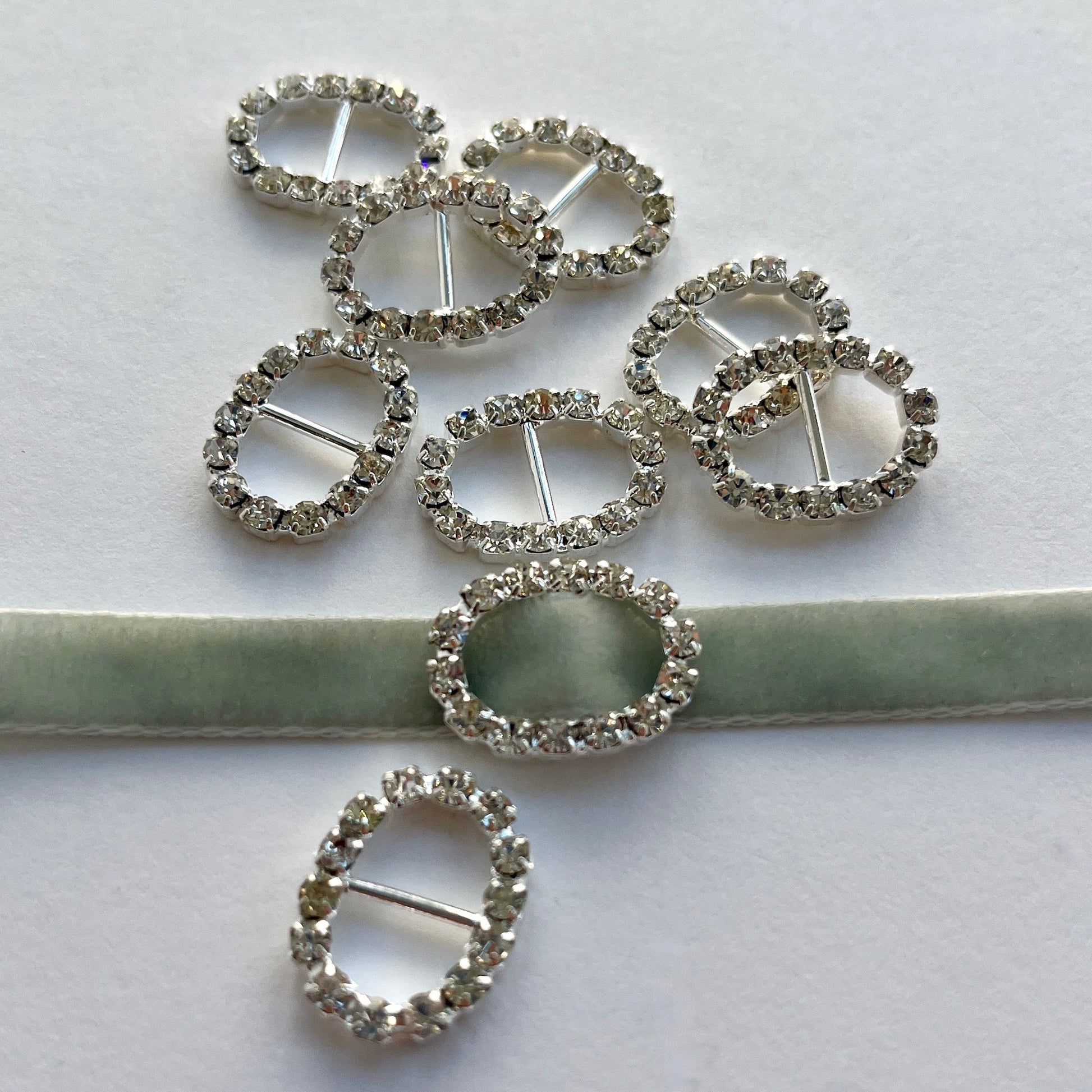 OVAL DIAMANTE SLIDER BUCKLE -Lovely, high quality, rhinestone crystal slider buckles. Easy to use, just slide onto a ribbon or a strap to add sparkle to dress straps, bags. Perfect for a spot of DIY to embellish wedding invitations, wedding favours, napkin rings and arts and craft projects. Shown on 1cm (⅜”) wide velvet ribbon.