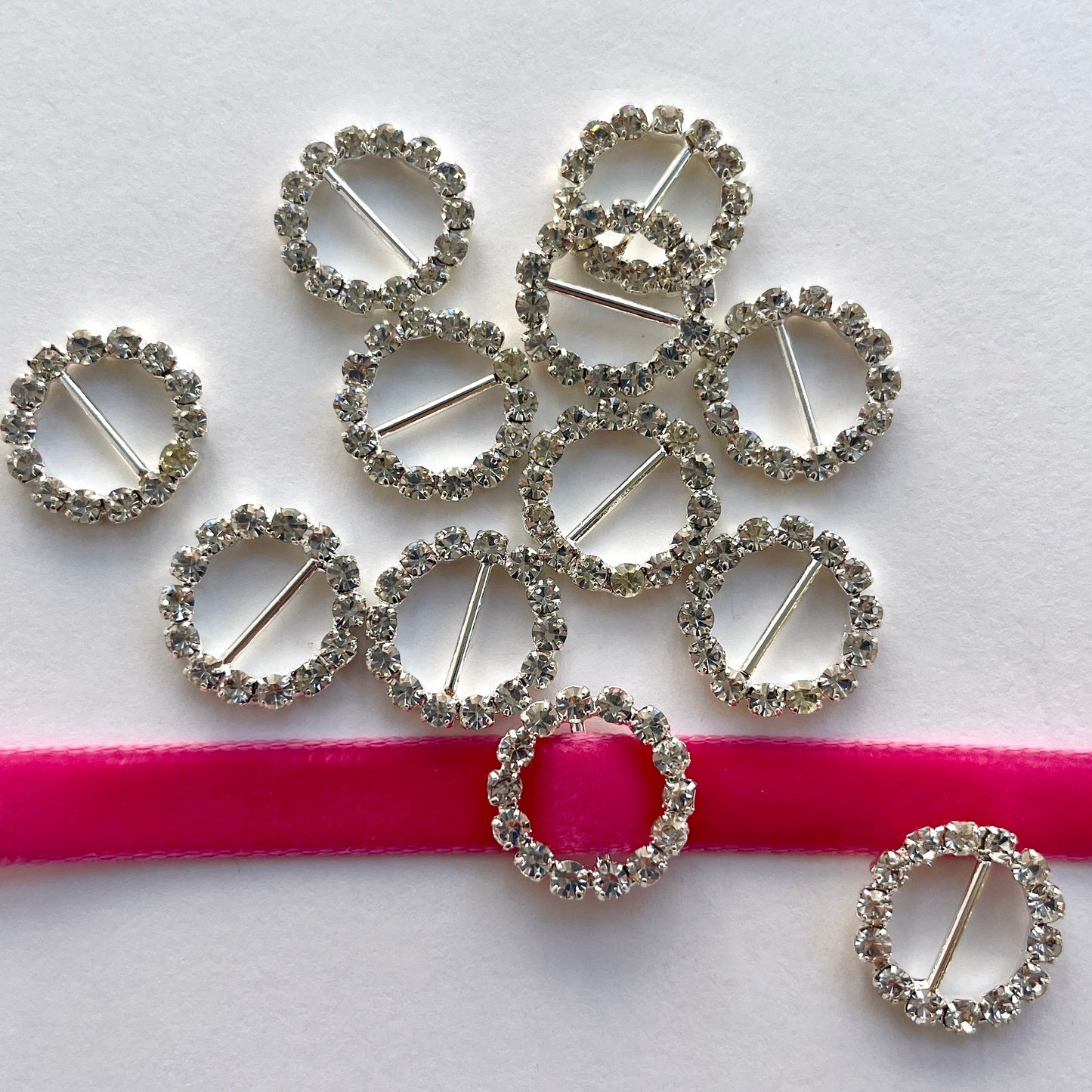 Lovely, high quality, rhinestone crystal slider buckles. Easy to use, just slide onto a ribbon or a strap to add sparkle to dress straps, bags. Perfect for a spot of DIY to embellish wedding invitations, wedding favours, napkin rings and arts and craft projects. Shown on 1cm (⅜”) wide velvet ribbon.