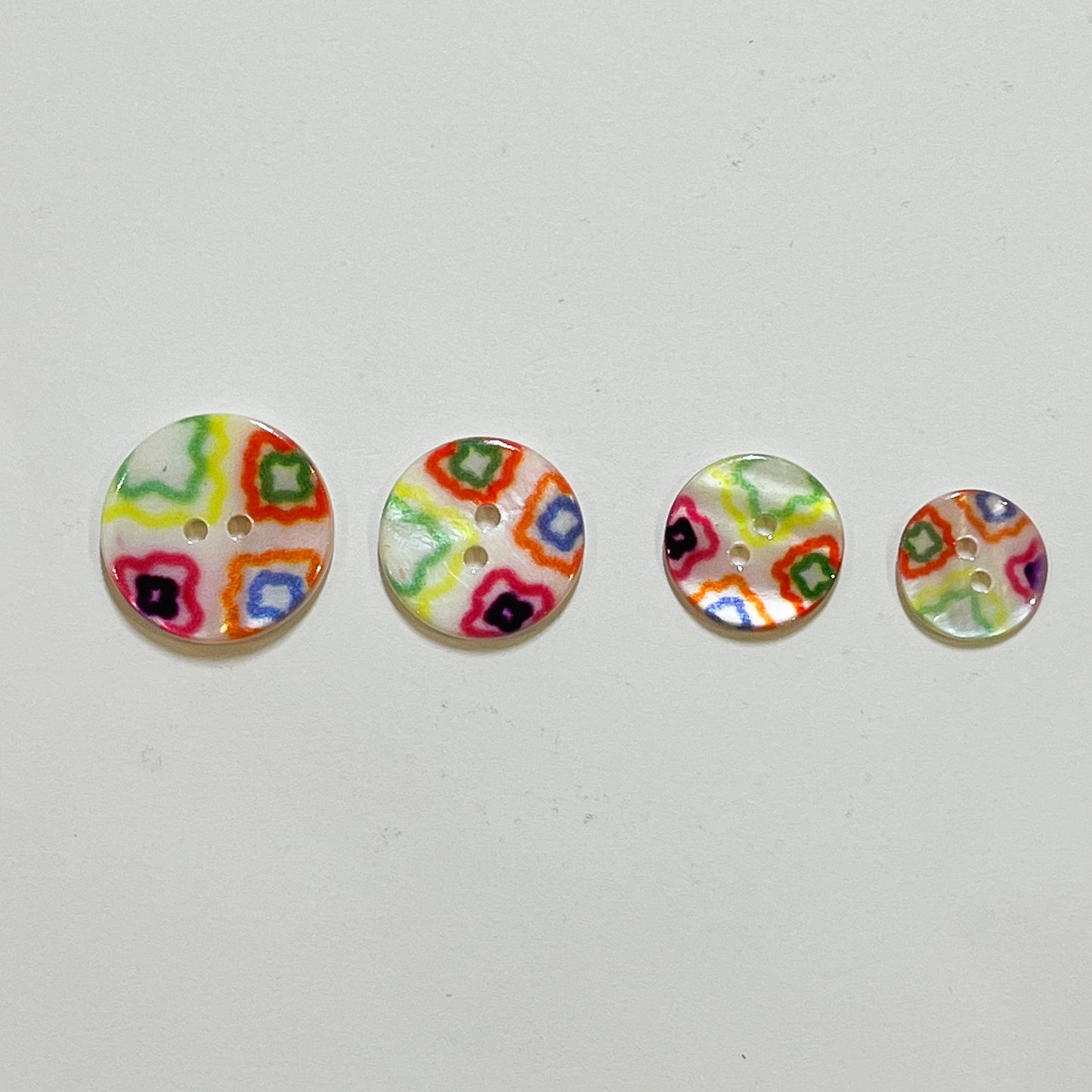Very pretty, 2 hole river shell buttons with a bright geometric design.