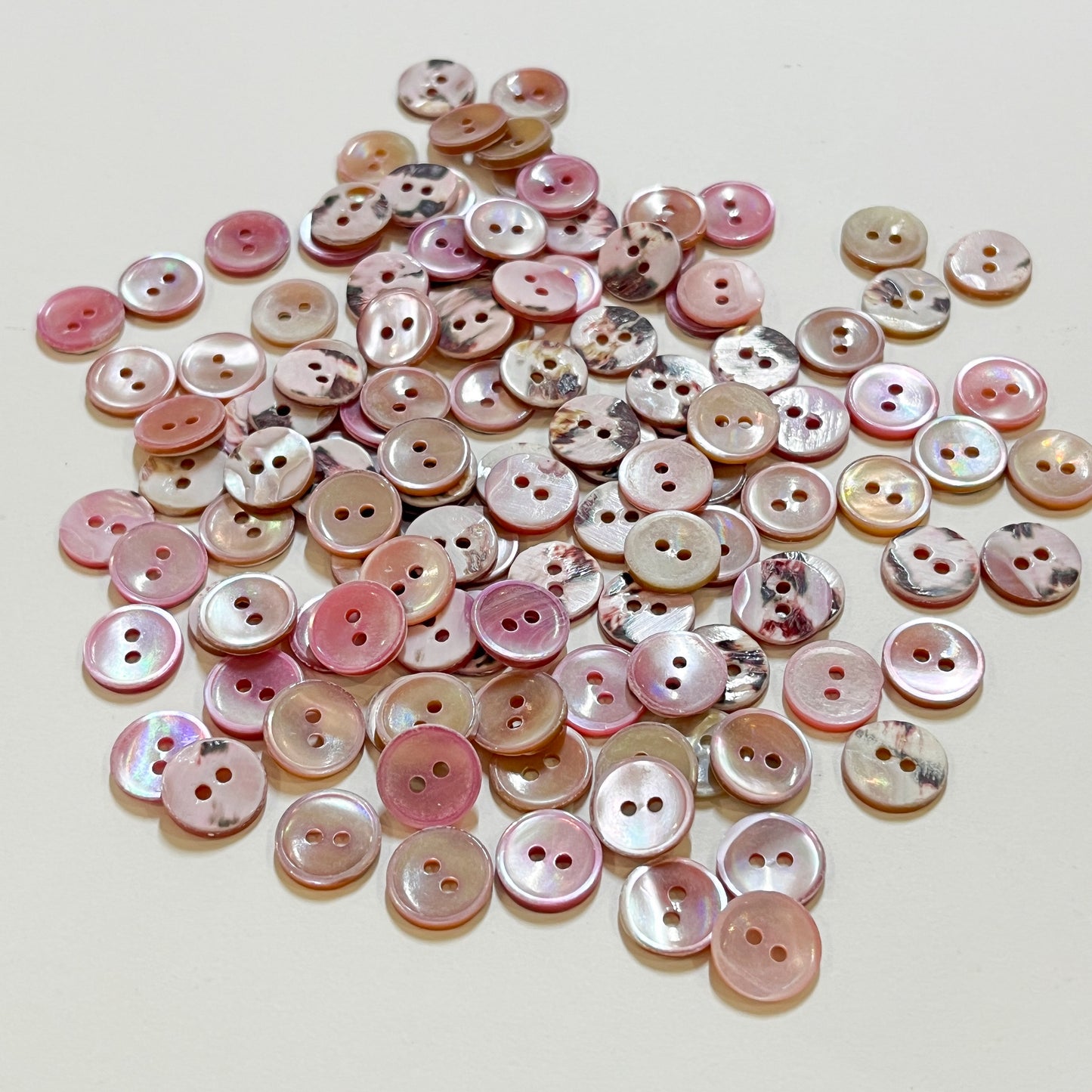 Set of 10 shirt buttons. Beautiful 2 hole Trocas shell shirt buttons in varying shades of pink.Deadstock shell buttons.