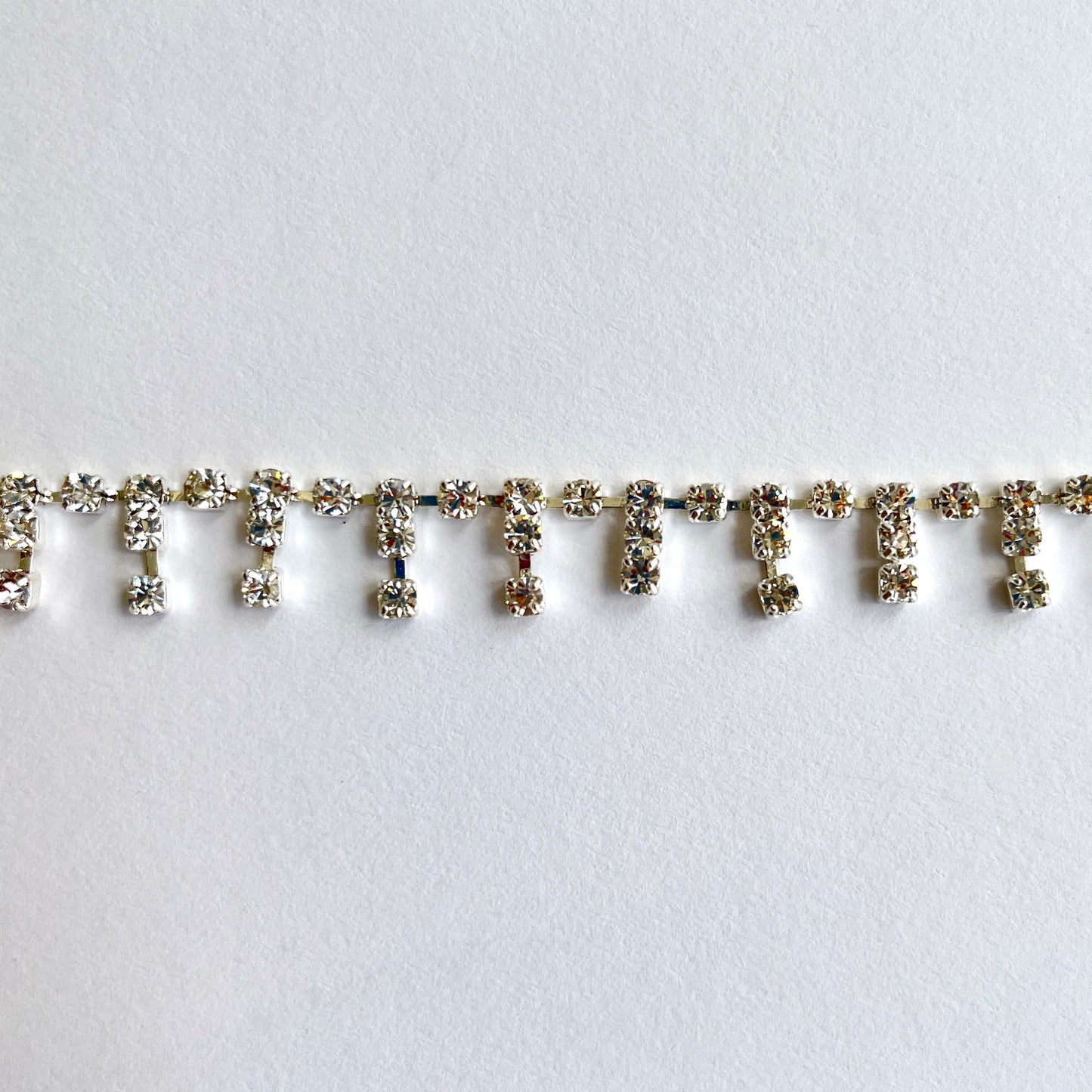 Delicate sparkly rhinestone fringe trim made premium high grade diamanté crystals set in a flexible metal chain casing. Popular for bridal wear, evening wear, crafts, jewellery and headband making.