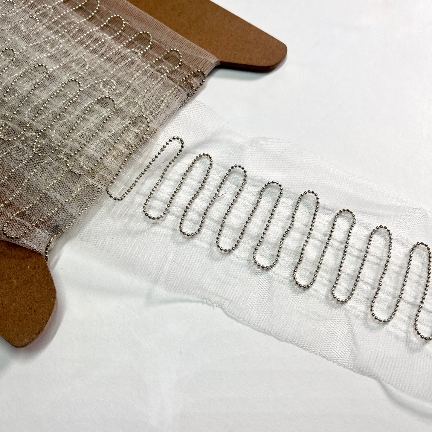This is a super fine and unusual beaded trim, with a 1.5mm ball chain expertly stitched in a Serpentine pattern to a tulle base which would be a great base for extra beading work, should it be required. Perfect to embellish borders, waists, for bridal wear, evening wear, crafts, jewellery and headband making.