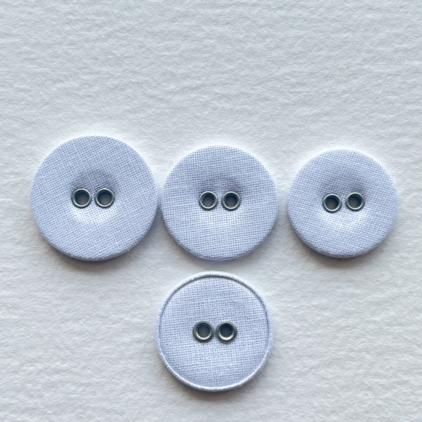 Lovely utilitarian, vintage style linen covered buttons. Flat with 2 holes and fabric on both sides of the button. Price is for 10 buttons Colour: white Sizes: 26 Ligne (16mm), 28 Ligne (18mm), 30 Ligne (19mm)