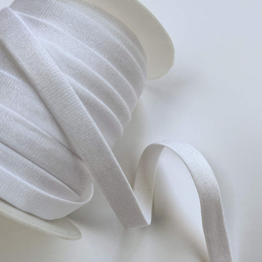 White satin bra elastic ribbon spool with a single loop of ribbon extending out on a clean white background.