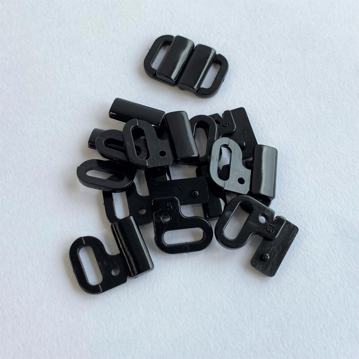 Black Bikin iClasps scattered on a white background