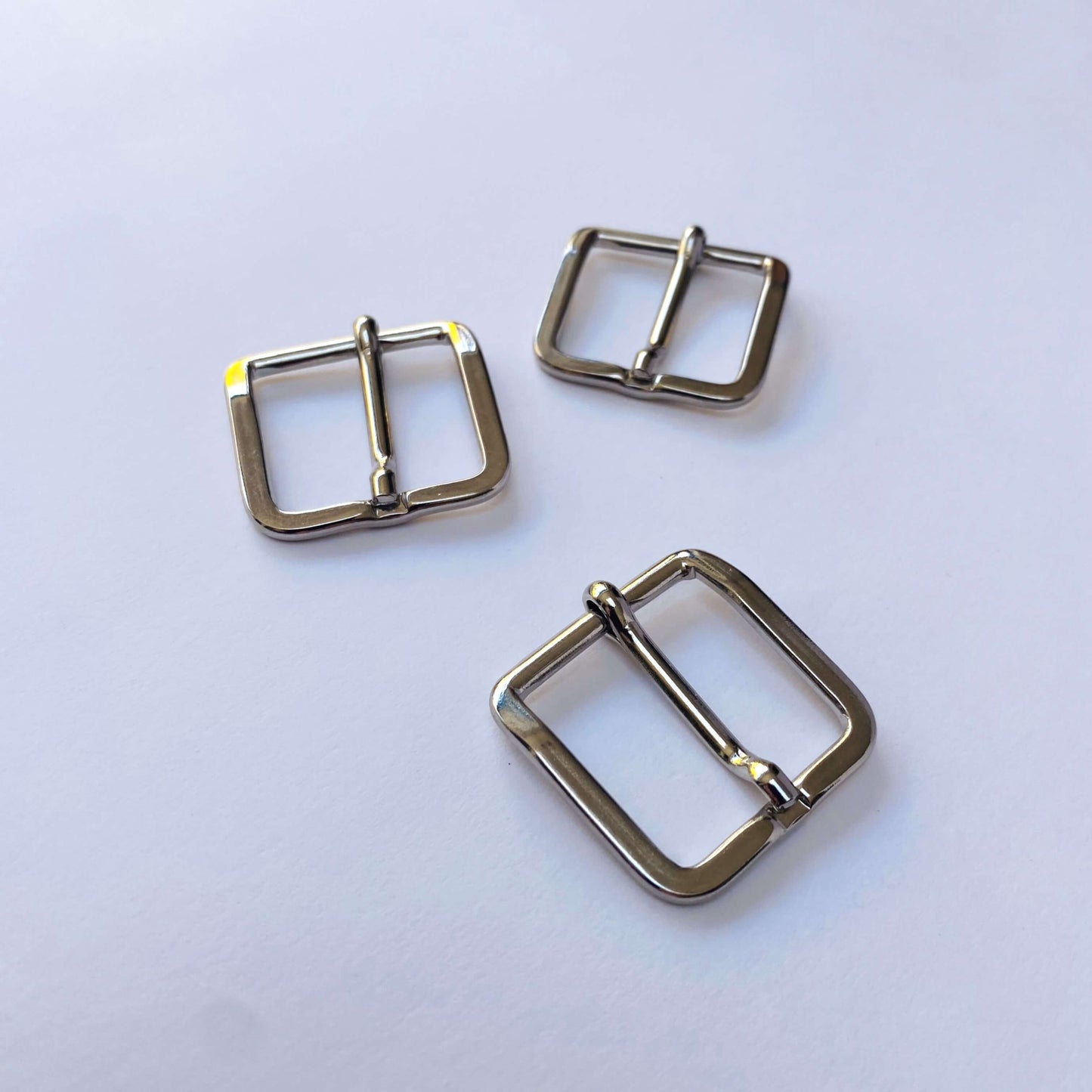 Three silver metal square prong buckles