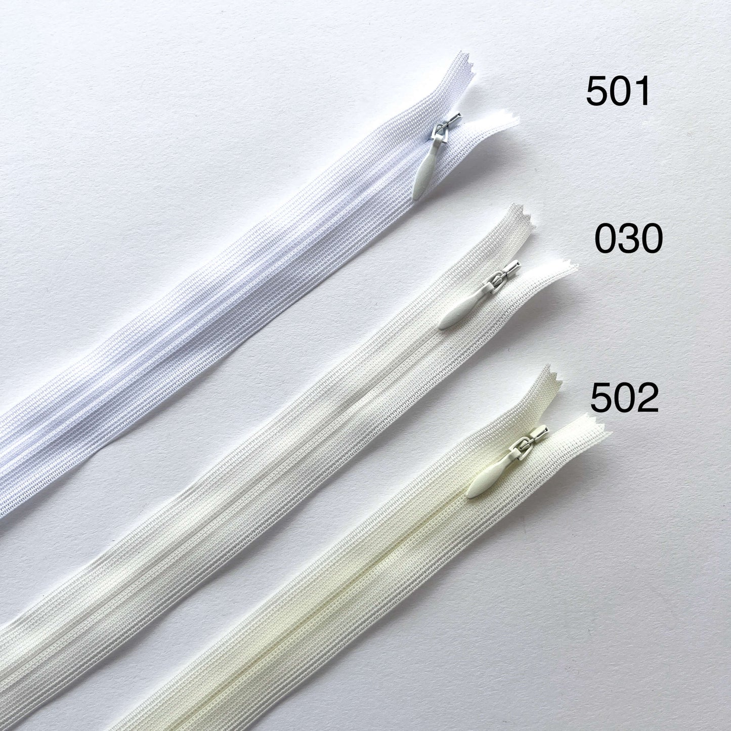 Three zippers labeled 501, 030, and 502 on a white background