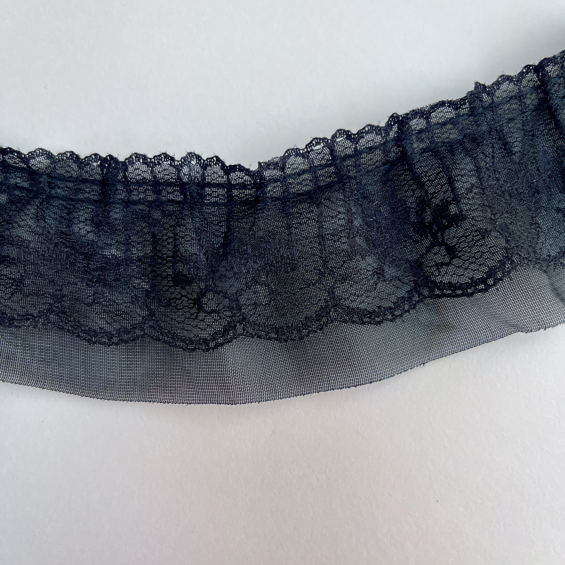 Close-up of black lace trim on a white background