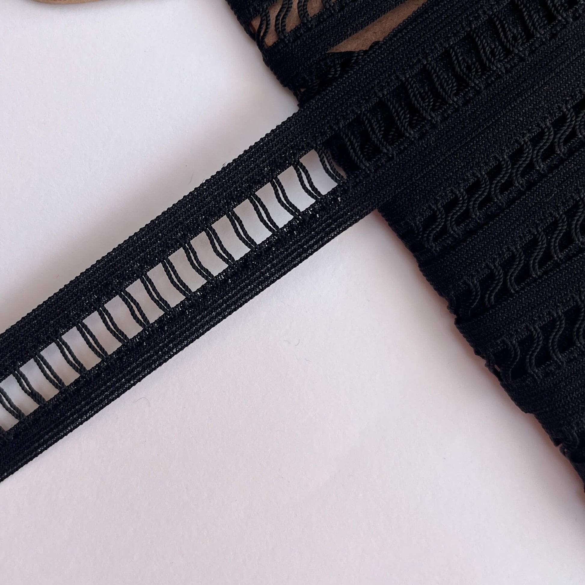 Close-up of Black Ladder Braid insertion Trim on a white background