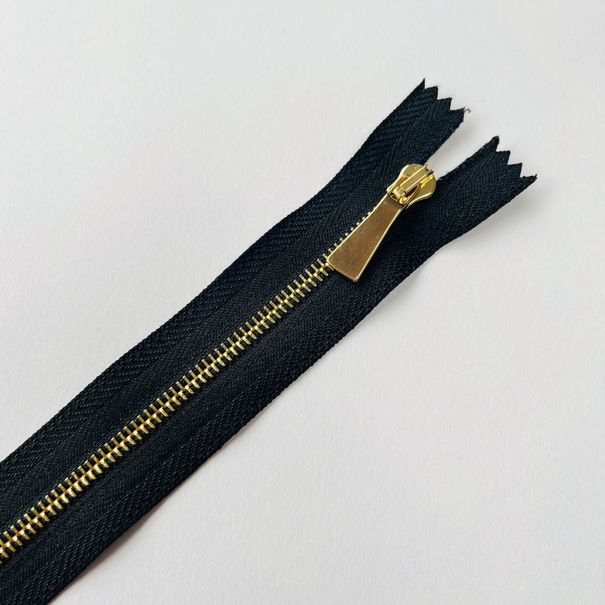 Close up of #3 Slim Profile Closed End Zip with black tape and Gold teeth & puller - 20cm length