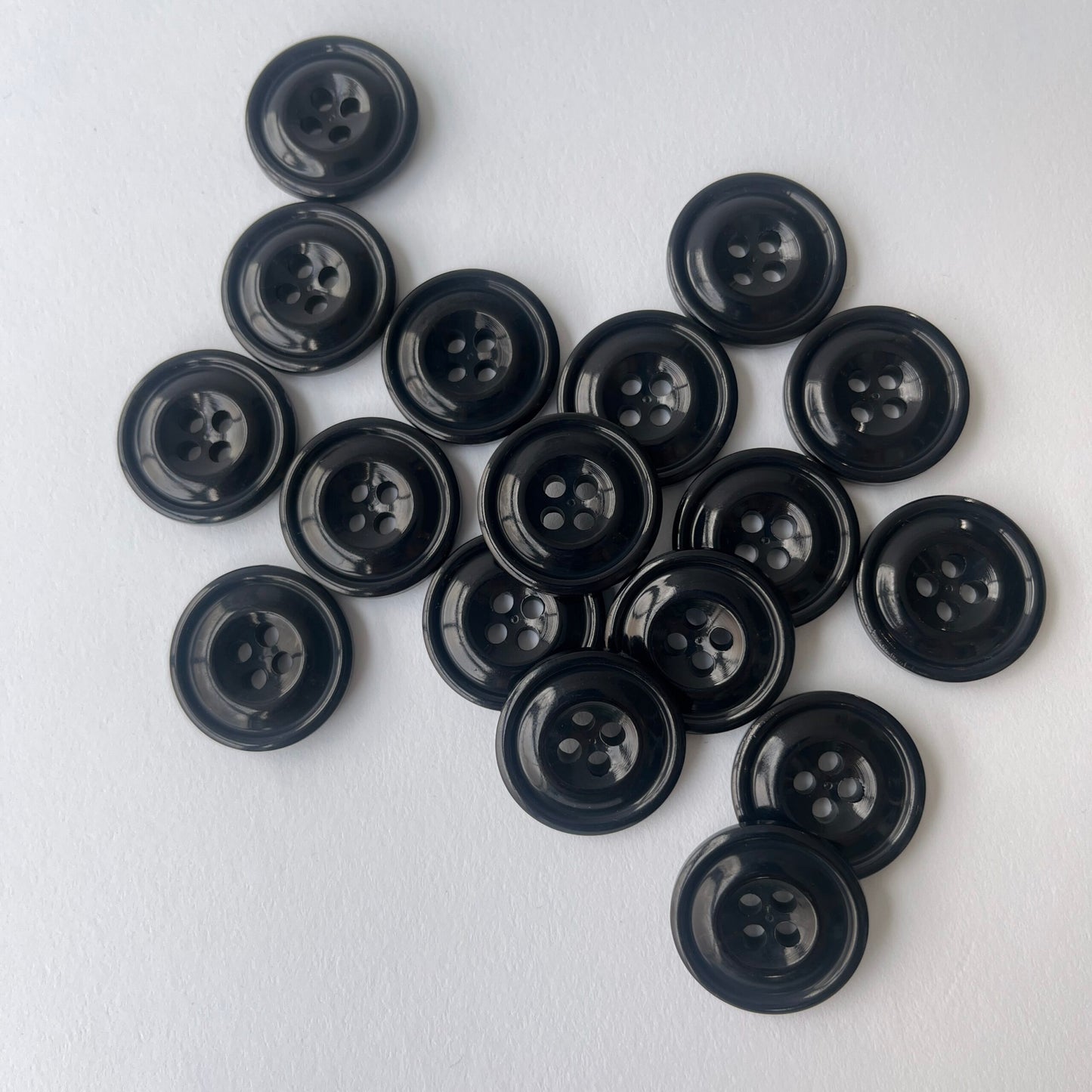 A group of Black Codelite Milk Buttons   of various sizes on a clean white background. Codelite buttons - plastic free, organic & sustainable.