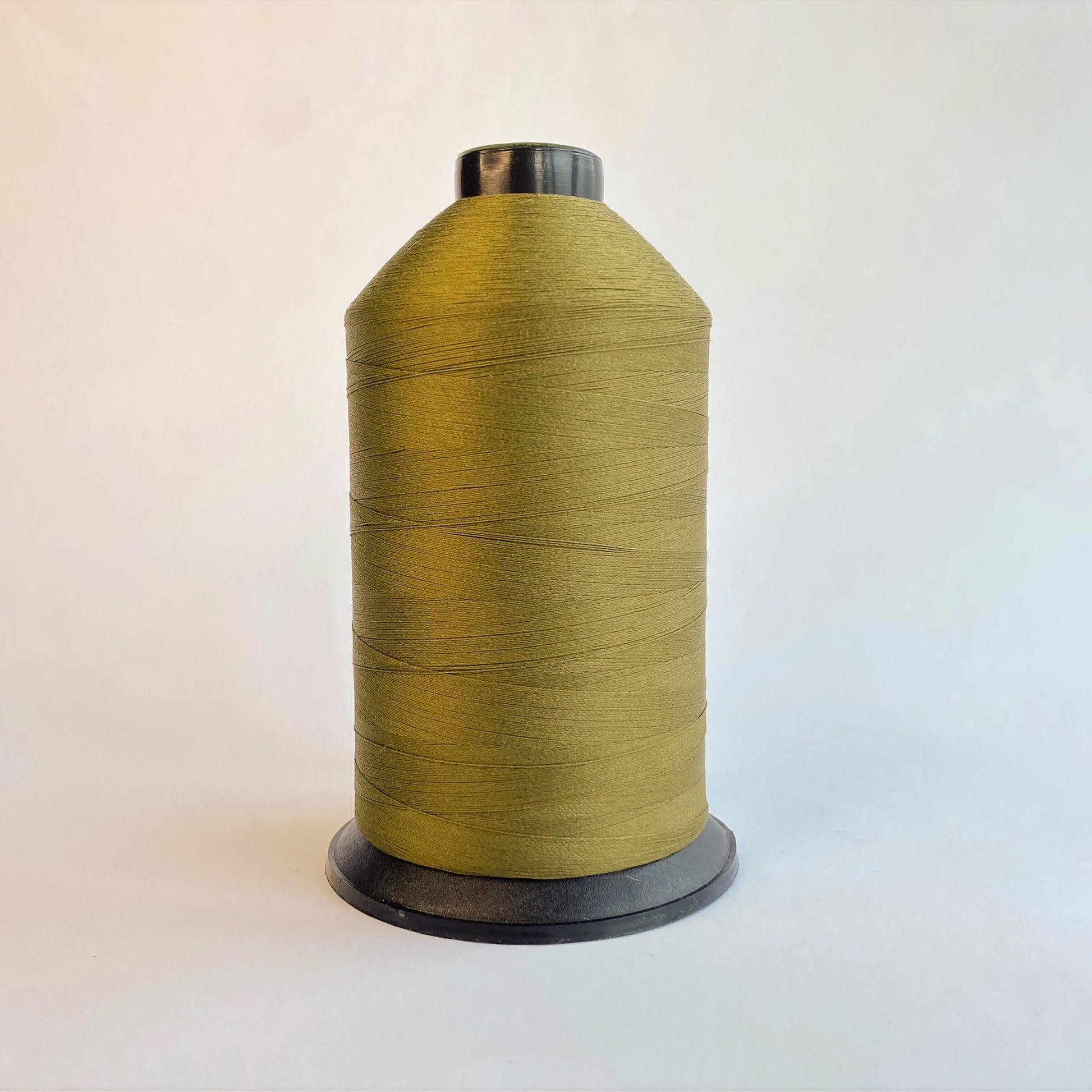 Spool of Dark Olive green sewing thread on a light background