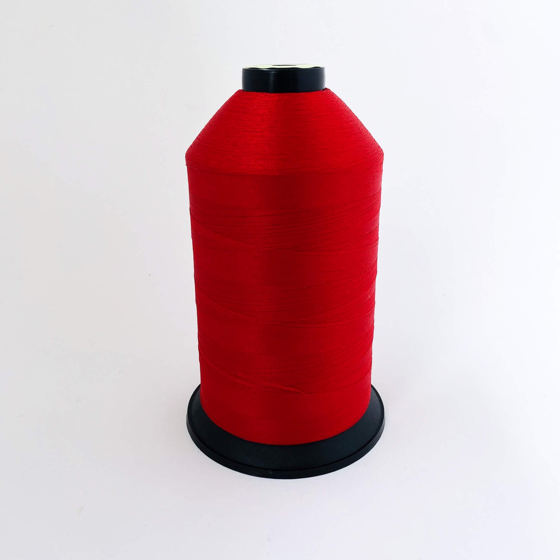 Red spool of thread on a white background