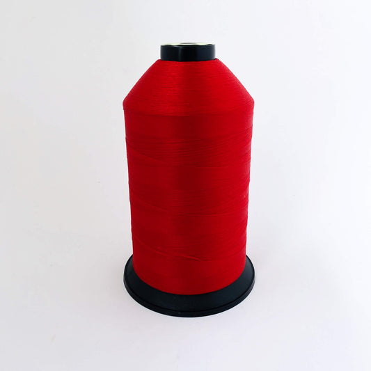 Red spool of thread on a white background