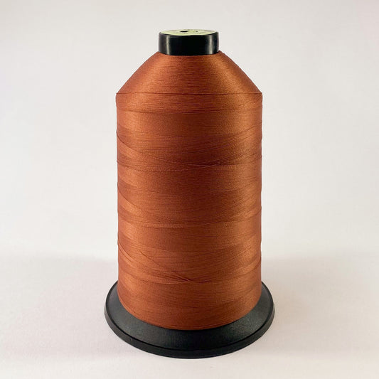 Spool of brown thread on a white background