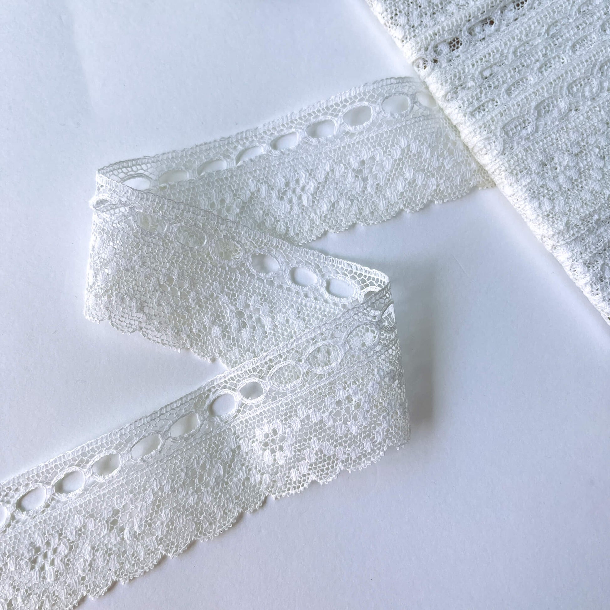 Close-up of a delicate ribbon slot Eyelet Lace Trim - 35mm wide on a white background