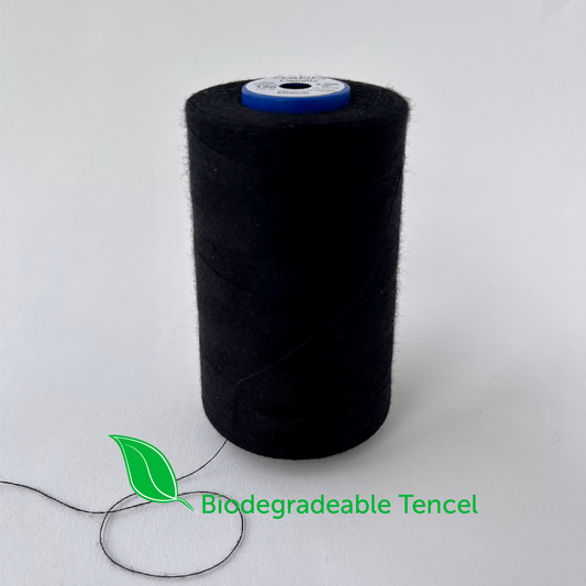 Spool of black thread with 'Biodegradable Tencel' label on a white background