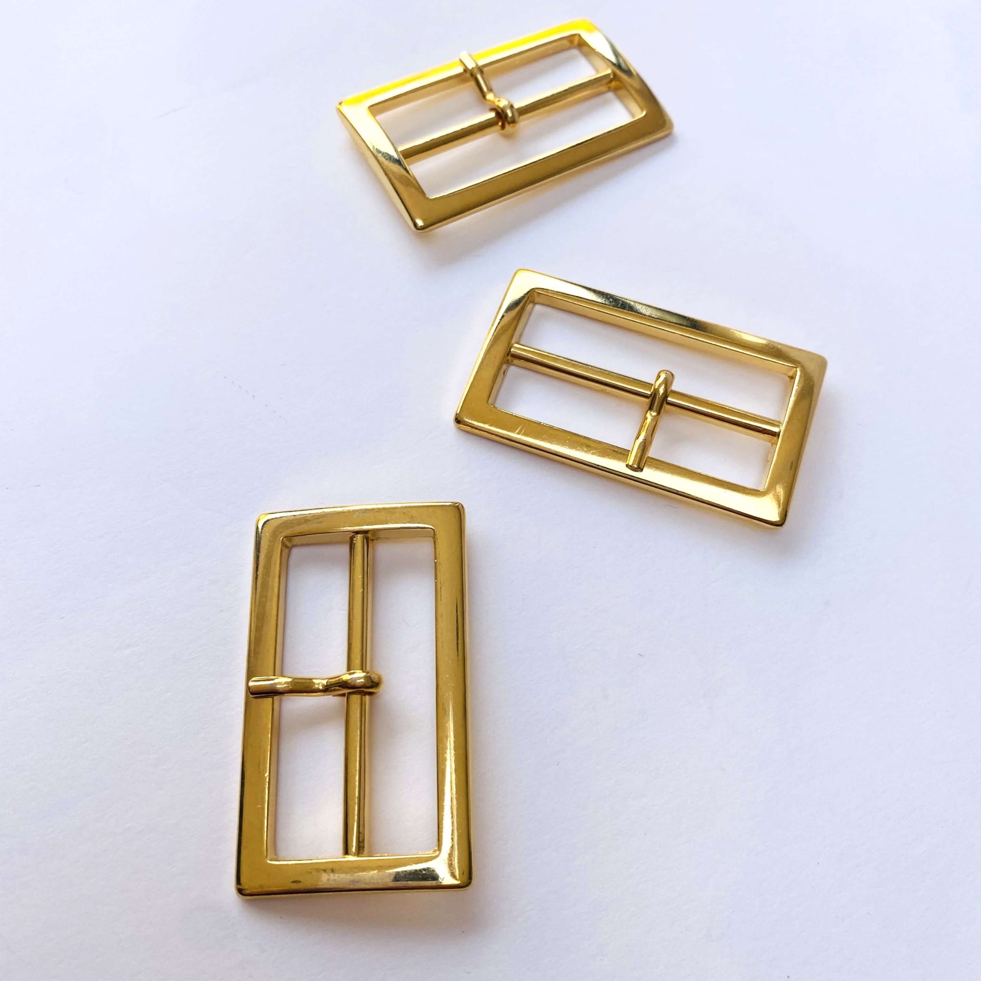 Gold Rectangle Prong Buckle - 40mm - Three gold belt buckles on a white background