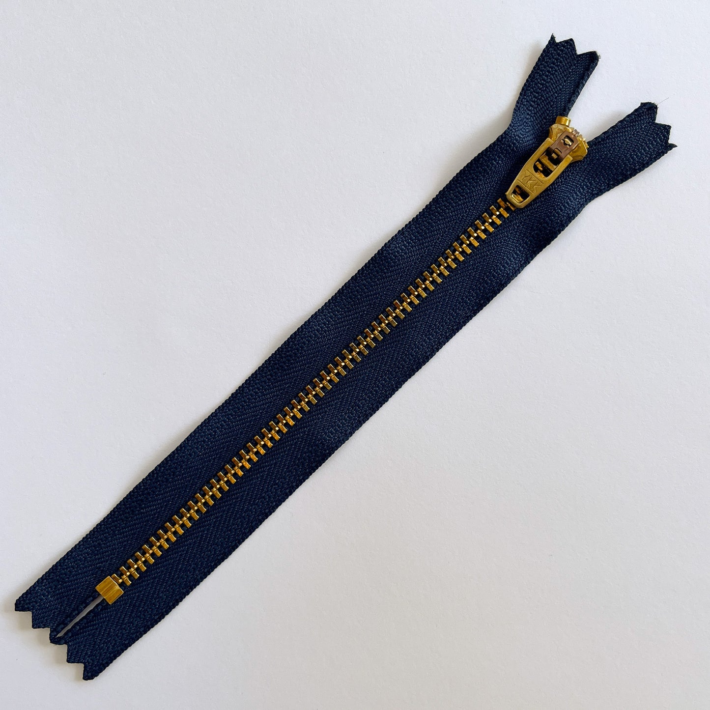 Blue zipper with gold teeth on a white background