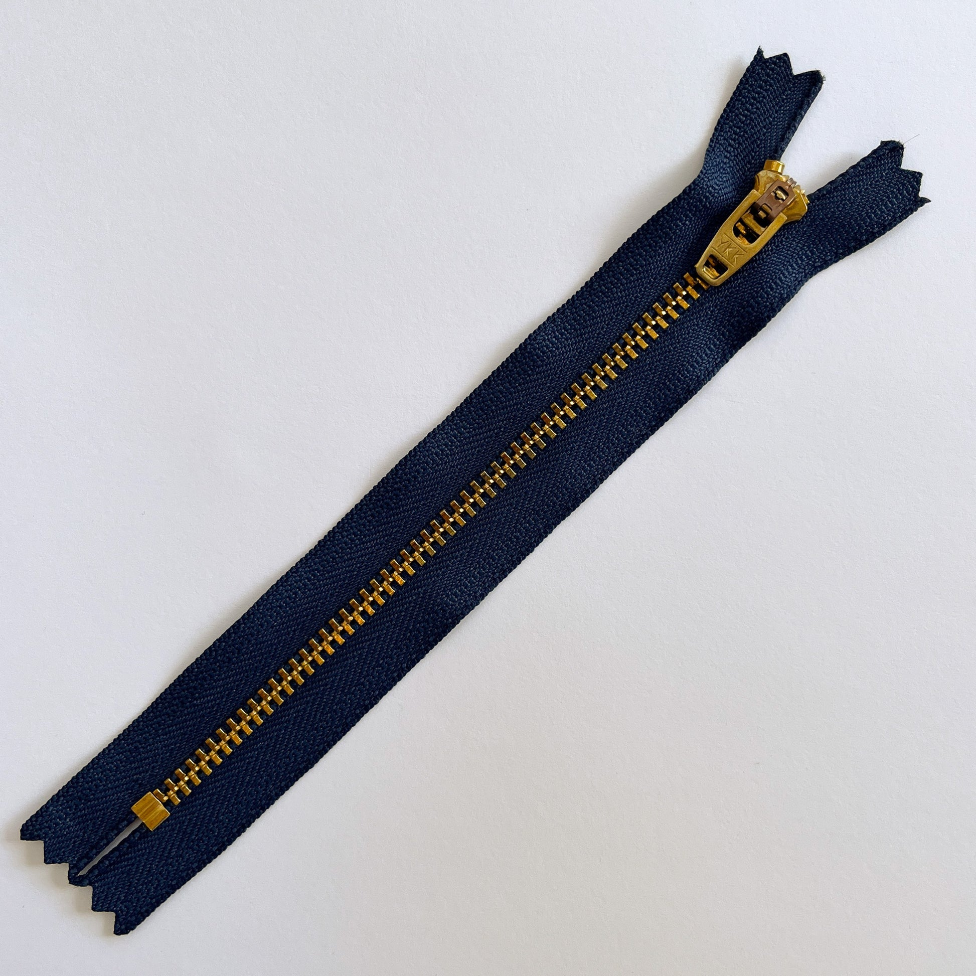 Blue zipper with gold teeth on a white background