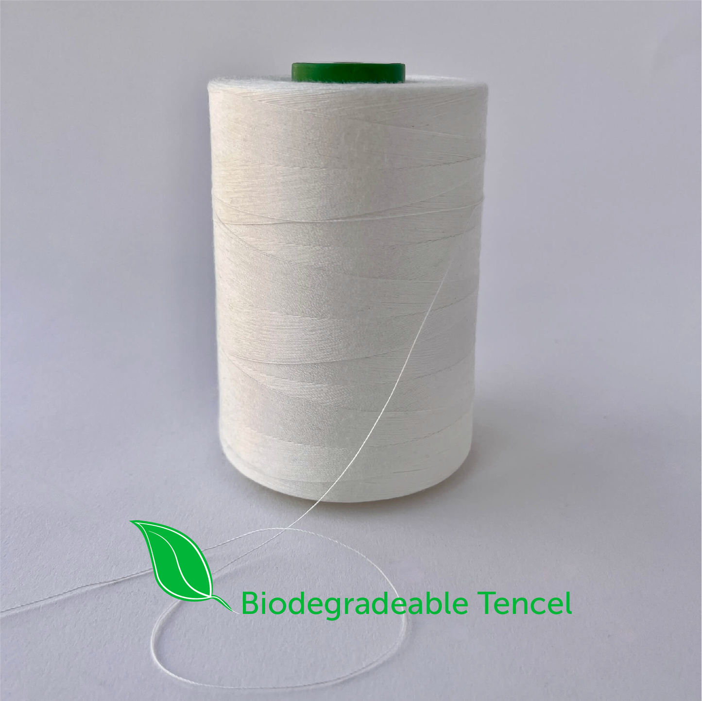 Spool of biodegradable tencel thread on a gray background