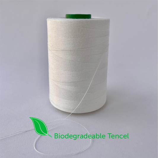 Spool of biodegradable tencel thread on a gray background