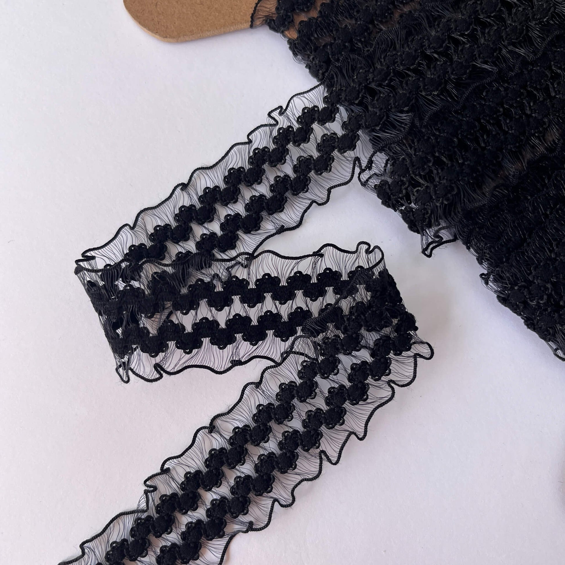Elasticated stretch Black lace trim on a white background