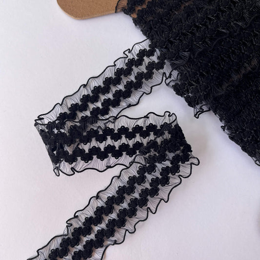 Elasticated stretch Black lace trim on a white background