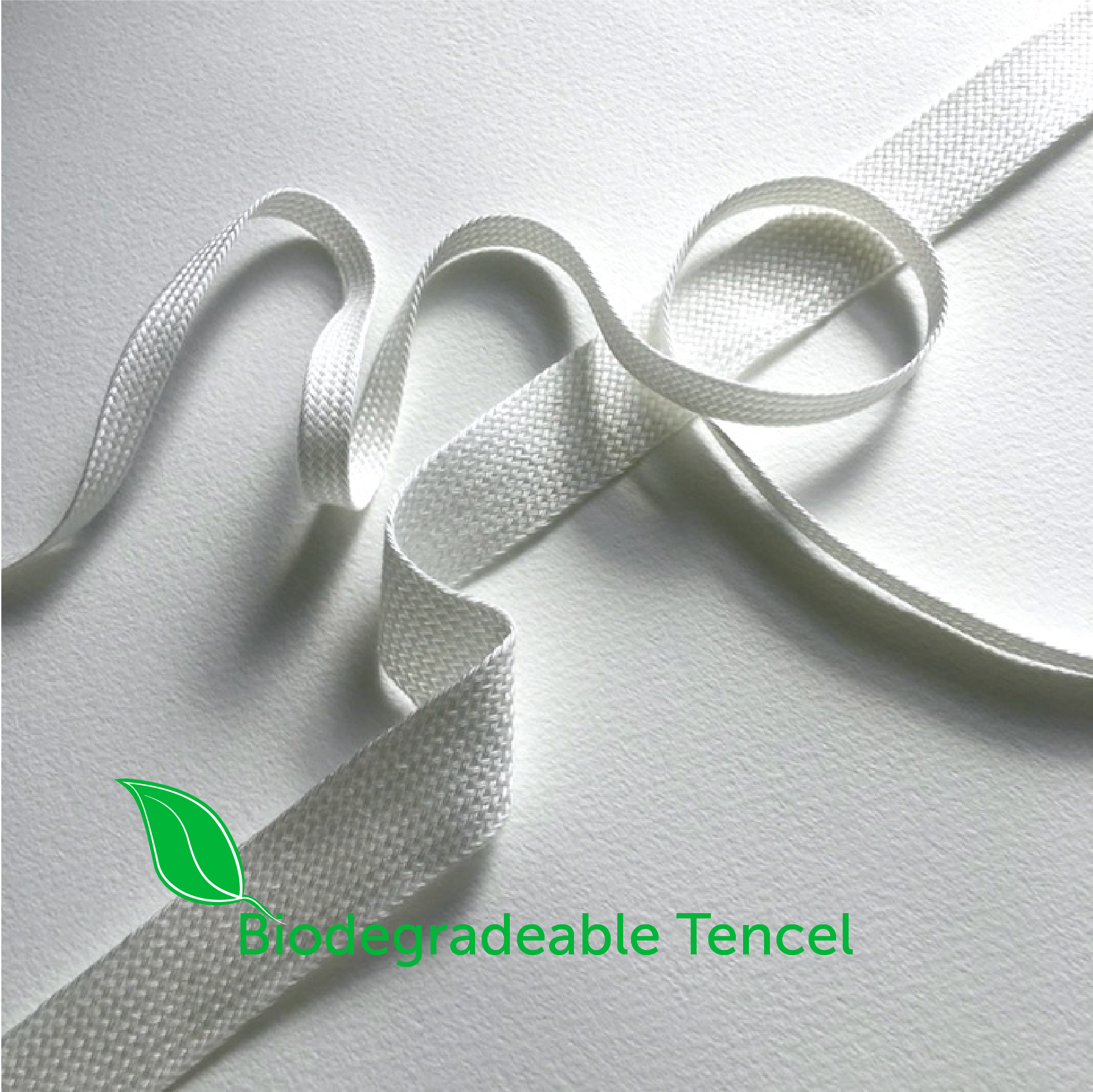 Biodegradable Tencel fabric on a white background with a green leaf logo.