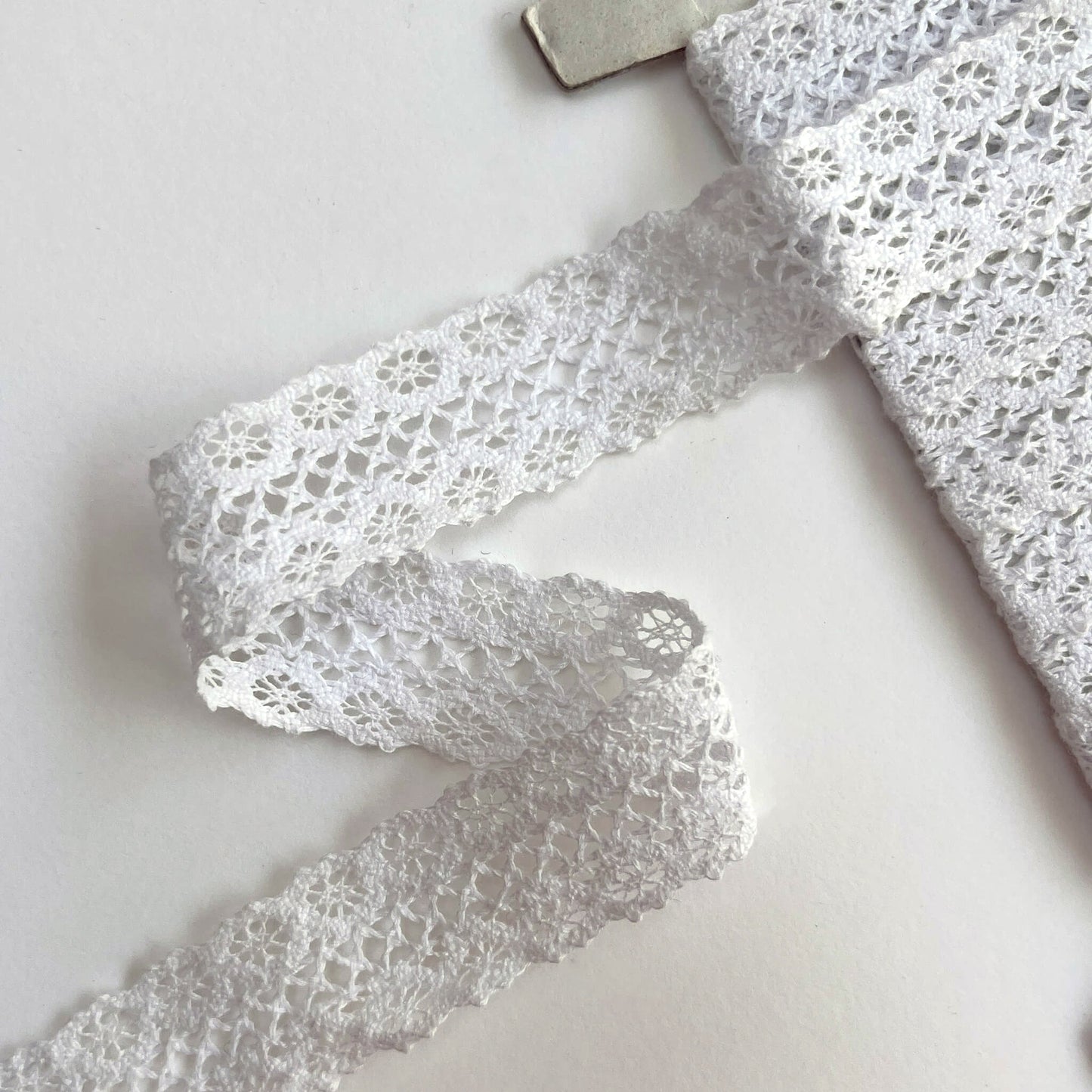 White cotton lace trim on a white background