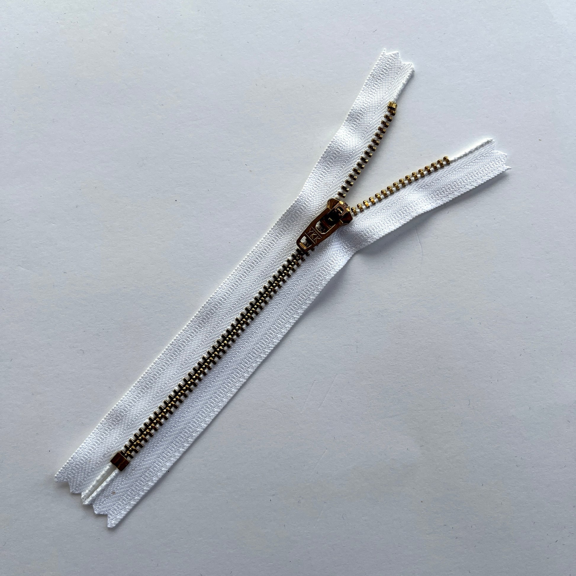 YKK white jeans zip with brass metal teeth and auto-lock puller