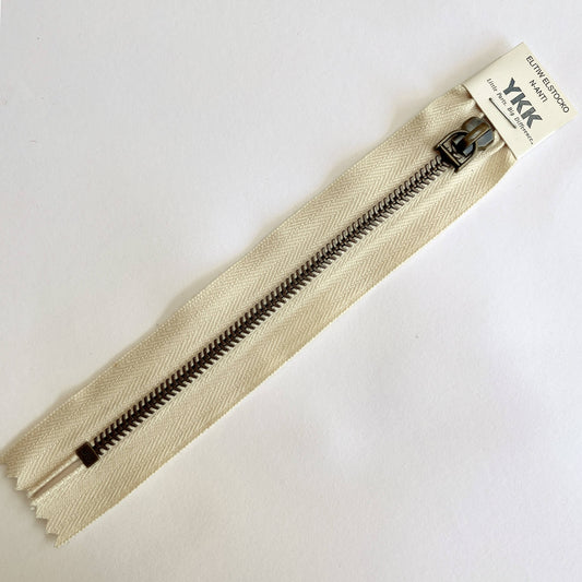 A YKK EXCELLA® Blade closed end zip with ecru tape, 'herringbone' style metal teeth and stirrup puller. 