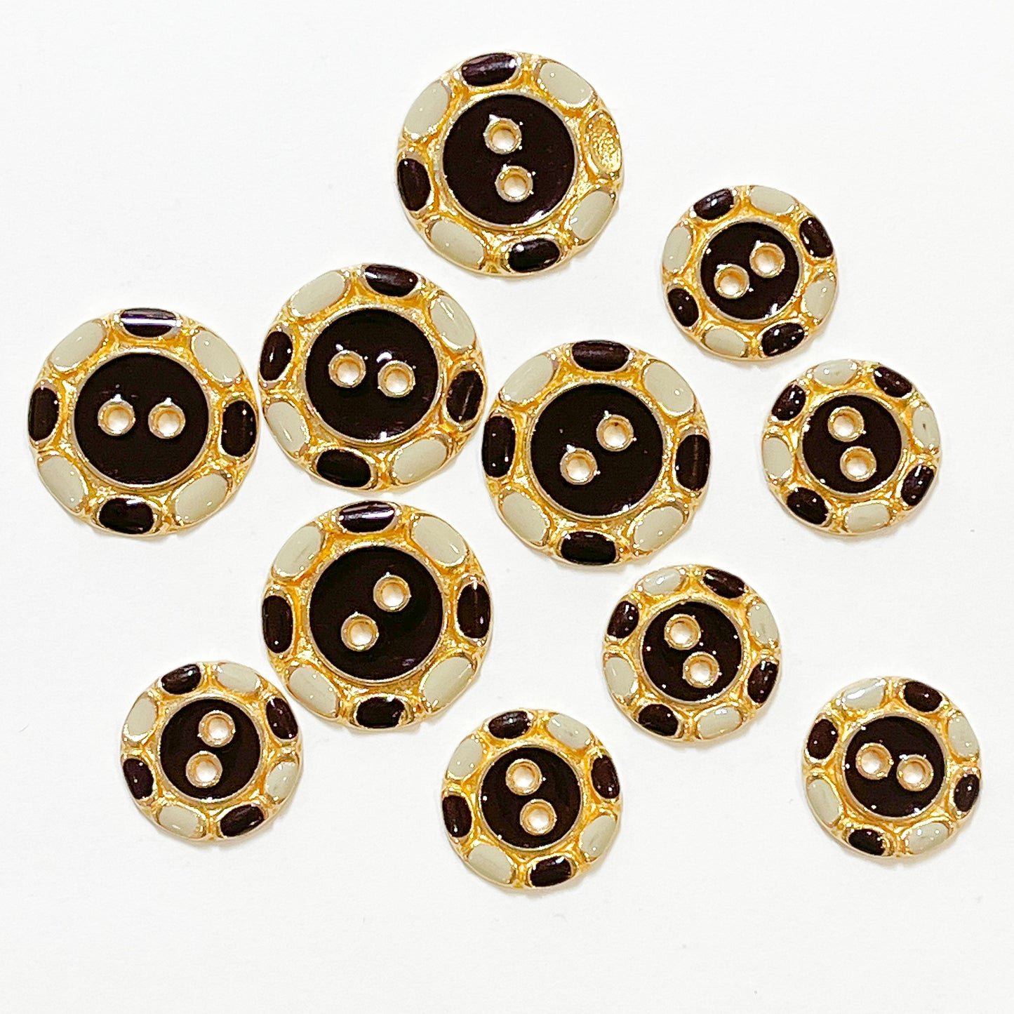 Set of 11 beautiful enamelled buttons from the 1980s. Flat with 2 holes and chestnut brown and ivory enamel work. In excellent condition but please note 1 of the large buttons has one spot of enamel missing