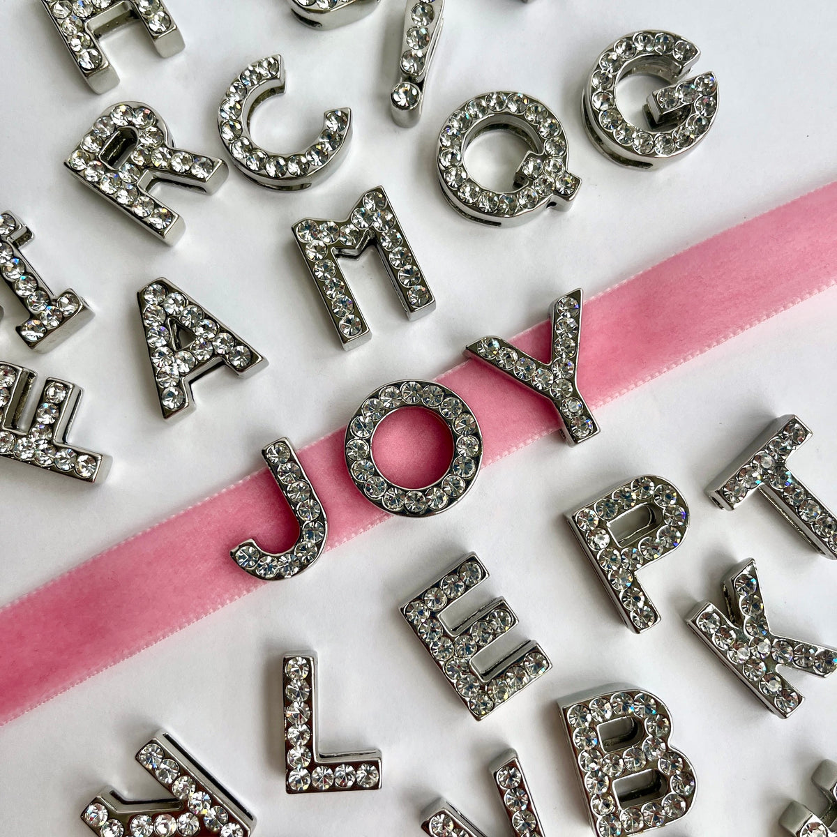 Close-up of 20mm silver rhinestone diamanté letter charms and symbols - KLEINS-DEADSTOCK-HABERDASHERY