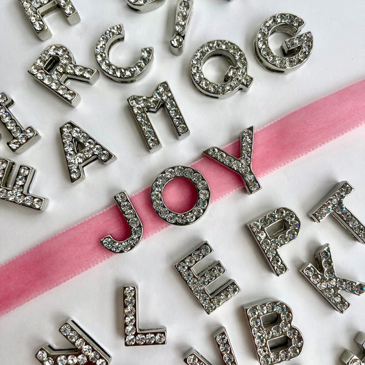 Close-up of 20mm silver rhinestone diamanté letter charms and symbols - KLEINS-DEADSTOCK-HABERDASHERY