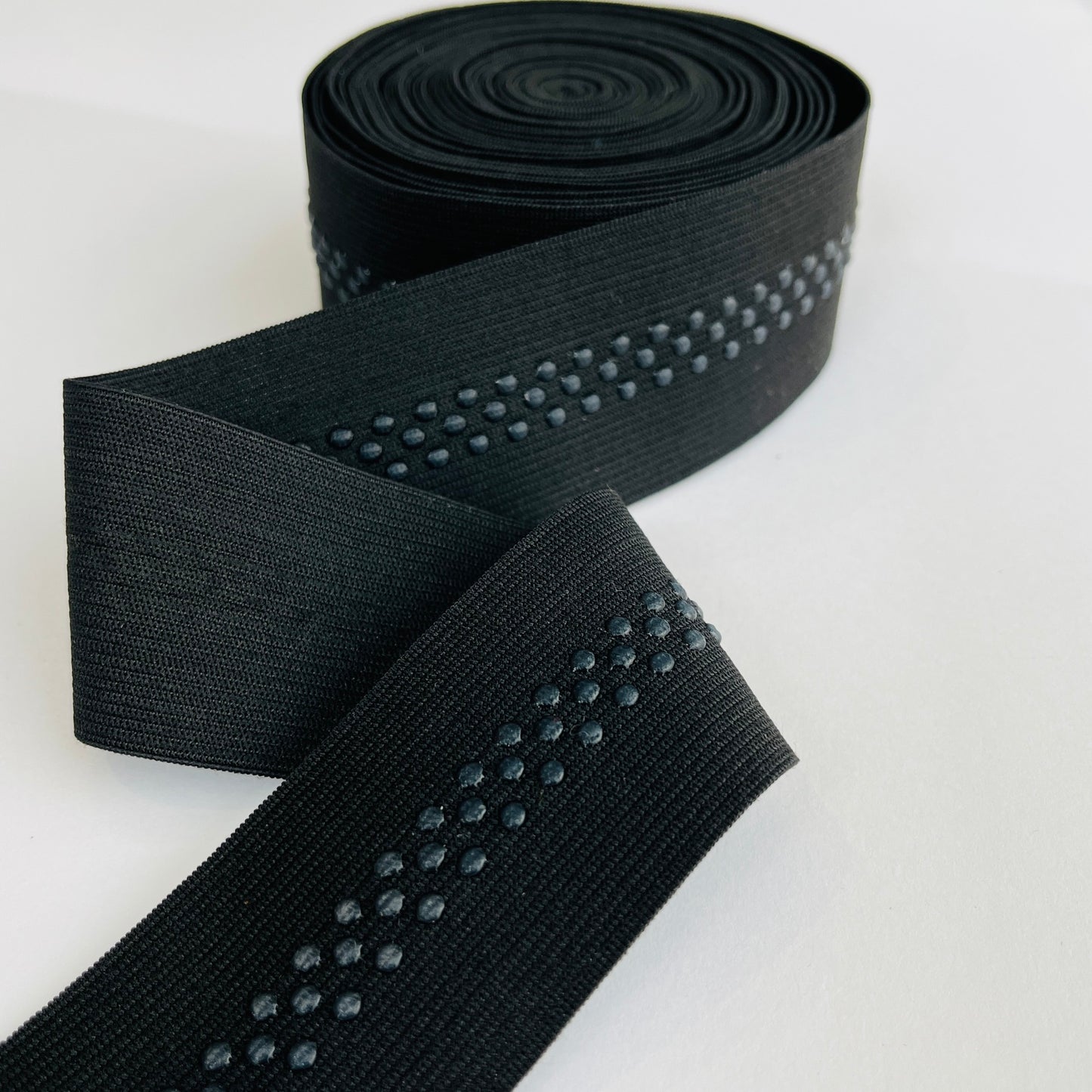 48mm, 2” wide silicone backed gripper elastic for headbands, waists, bra straps and lingerie 48mm wide with the drop silicone beads running at a 10mm width dead centre Soft gripper elastic with a 10mm wide band of non-slip silicone beads running centrally to help prevent movement when worn. Perfect for headbands, waistbands, activewear and lingerie. 